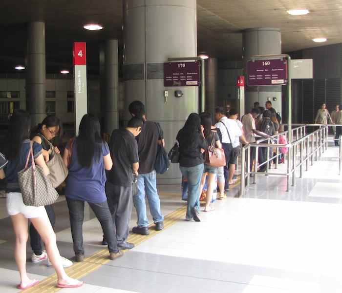 photo of people standing in lines for bus to Singapore at Malaysia CIQ