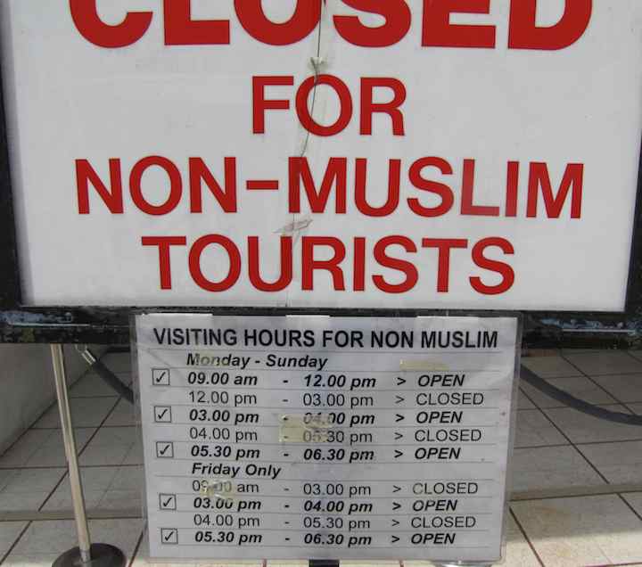photo of sign showing the hours tourists can enter the mosque